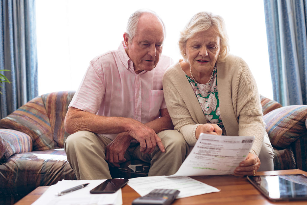 Couple discussing over medical bill while sitting on sofa