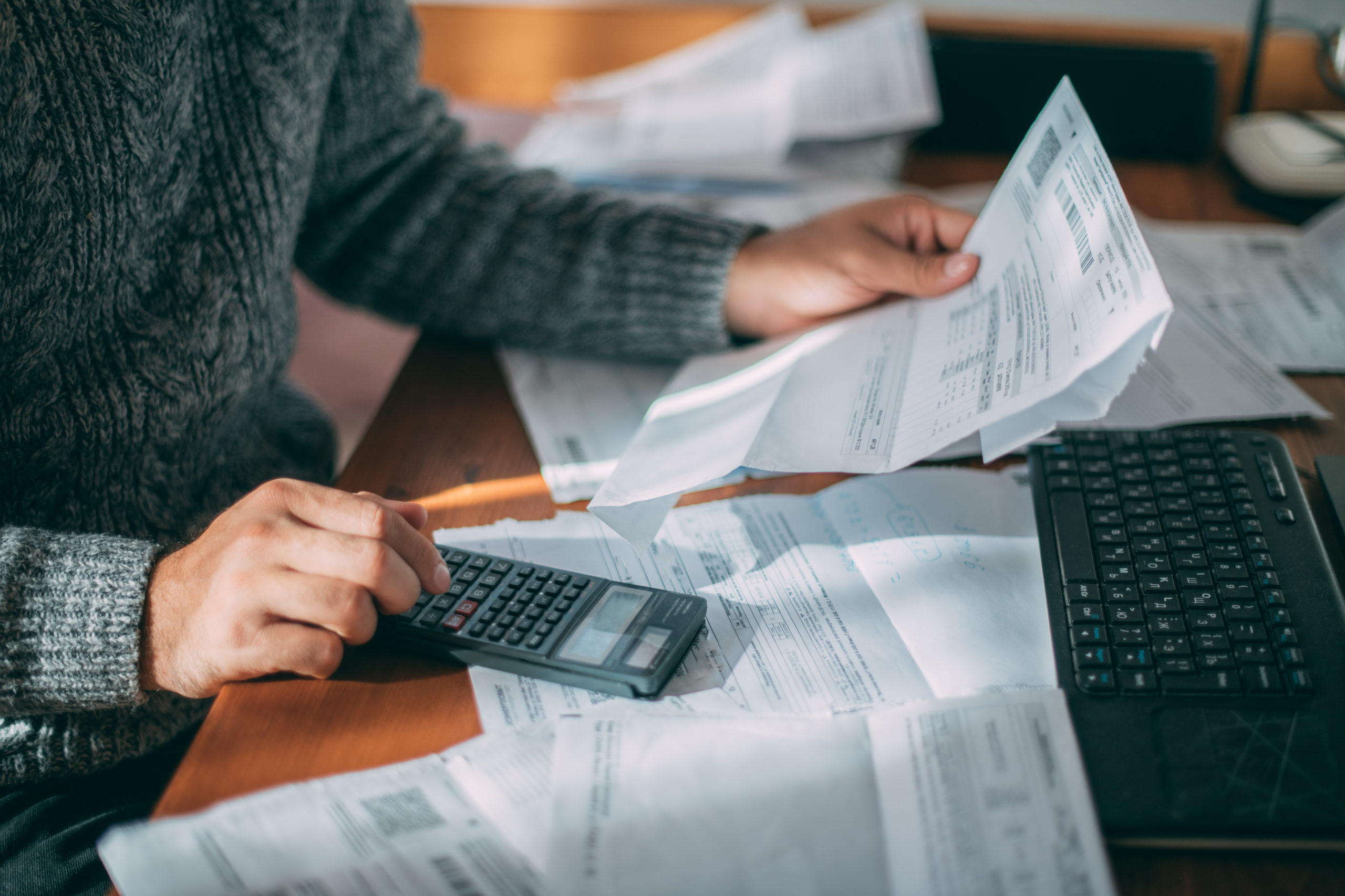 close up of patient differentiating between zero-interest patient financing vs. medical credit cards, reviewing many medical bills with calculator