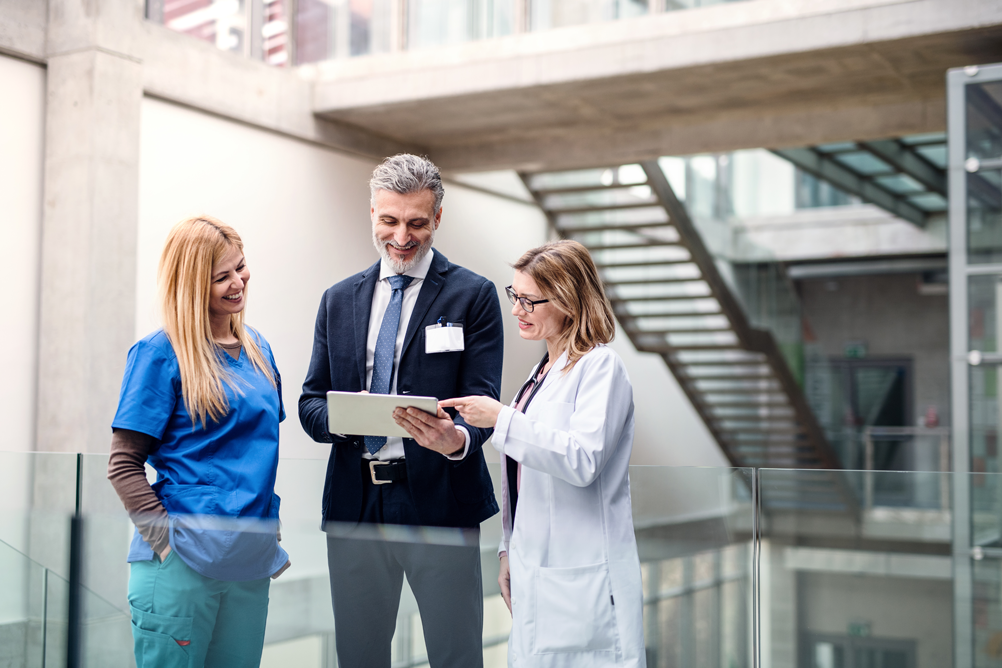 three happy staff discussing hospital operating margins after converting aged ar to payment plans