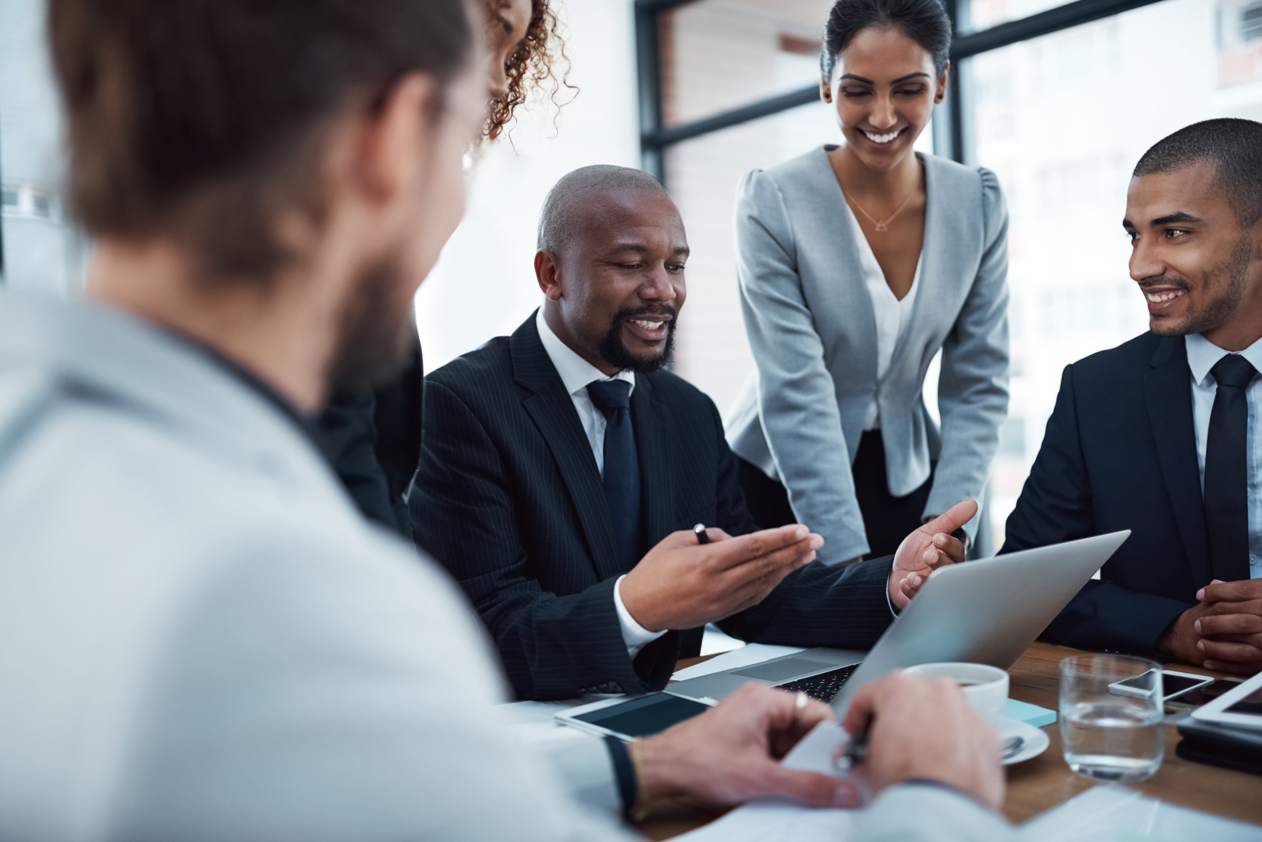 Shot of a group of businesspeople discussing something on a laptop