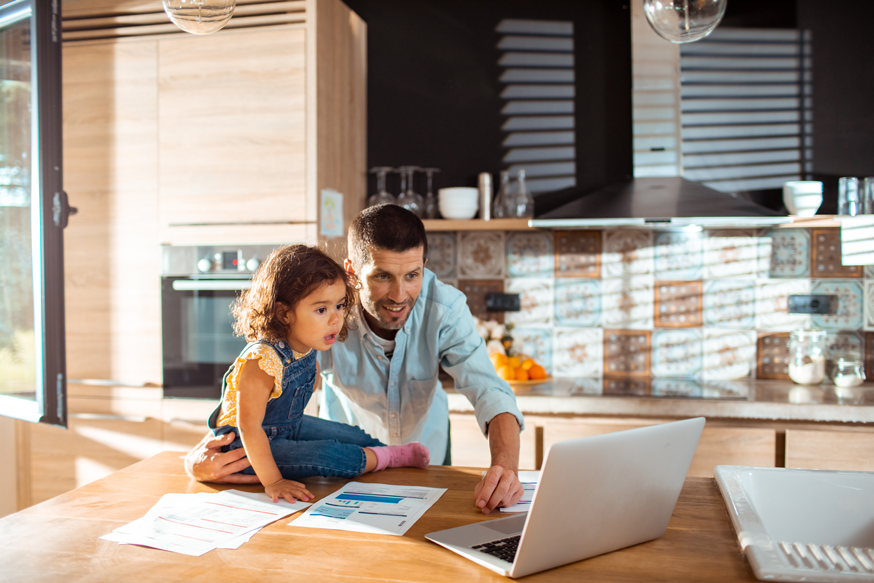 father using healthcare payment processing software for pre-care enrollment with daughter in kitchen
