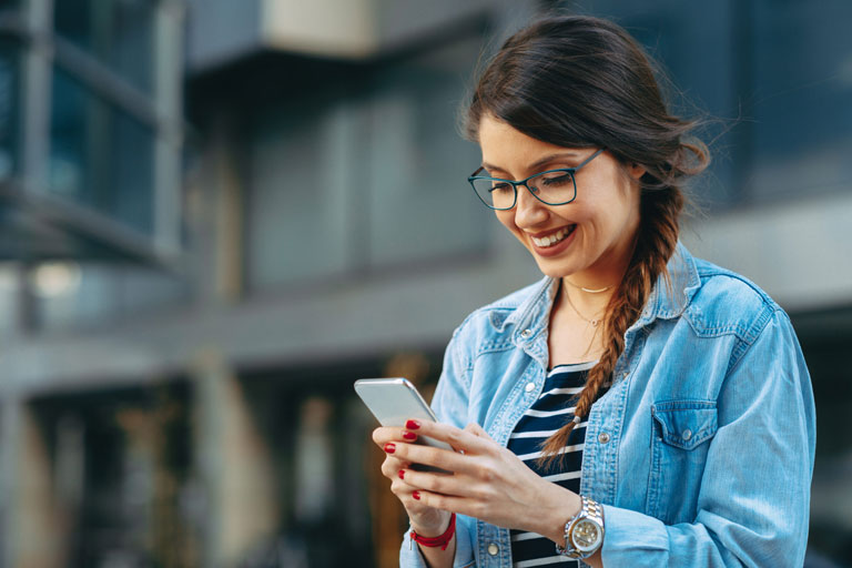 young woman smiling and messaging in advanced patient engagement platform